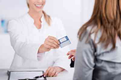 Patientin und Arzthelferin mit Versicherungskarte 